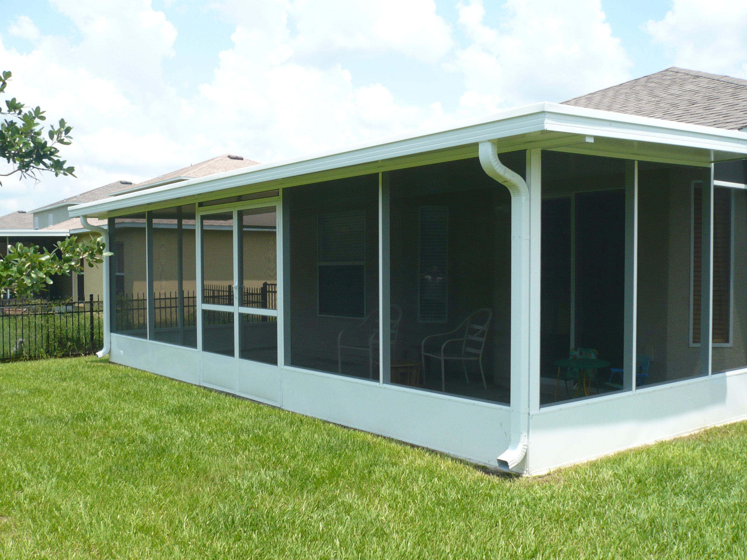 A white enclosed patio with an open roof.